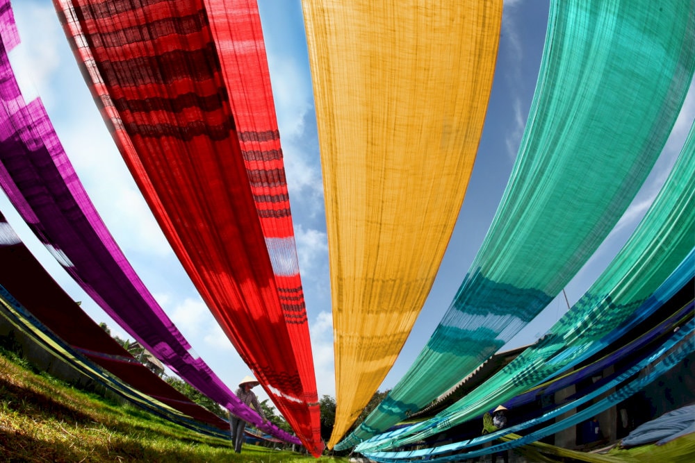 The sunlight beautifully enhances the vibrant silk and rustic charm of Van Phuc Silk Village